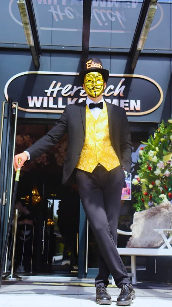 Mr. Cash mit Konfettikanone vor dem Eingang